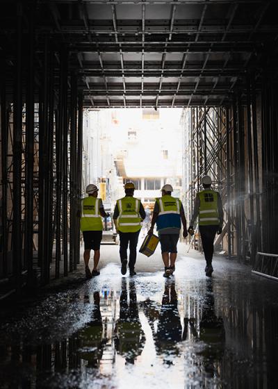 4 Männer gehen durch einen dunklen Tunnel