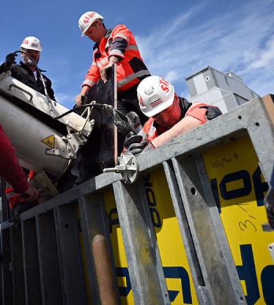 Construction workers pouring concrete into a functional prototype of an intelligent heated formwork