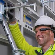 Worker using a head mounted device to adjust the formwork correctly.