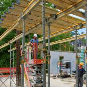 Bei der Deckenhöhe von ca. 3,60 m wird die Deckenschalung Dokaflex 30 mit Hilfe einer Scherenbühne von unten aufgestellt. Foto: Doka