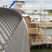 Die Schalung steht auf einer von Tauchern unter Wasser auf dem Fundamentvorsprung verankerten Arbeitsplattform, die von oben über einen Treppenturm erreichbar ist.