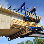 Sicherheit auf der Baustelle bieten integrierte Bühnen und Aufstiege des Freivorbauwagens sowie 350 lfm Seitenschutzgeländer XP in den fertigen Abschnitten