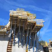 The box-outs for guiding the weir shutters were integrated into the wall before pouring. The stepped custom-built platforms provide a safe working environment.