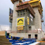 Die Montage der trapezförmig zugeschnittenen und bis zu 105 m² großen Schutzschilde Xclimb 60 erfolgt just-in-time durch Doka-Personal auf der Baustelle.
<br />
Foto: Doka