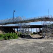 Systémové lešenie Ringlock je nasadené ako dočasný most ponad železnicu a starý most v havarijnom stave pred jeho demoláciou. 