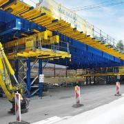 Die 22 m langen HEB800-Träger lagern auf zwei Lasttürmen 1000 mit 1000 kN Tragkraft pro Stütze. Die großzügigen Konsolbühnen sorgen für die notwendige Sicherheit für die Arbeiter beim Ein- und Ausschalen. Copyright: Doka